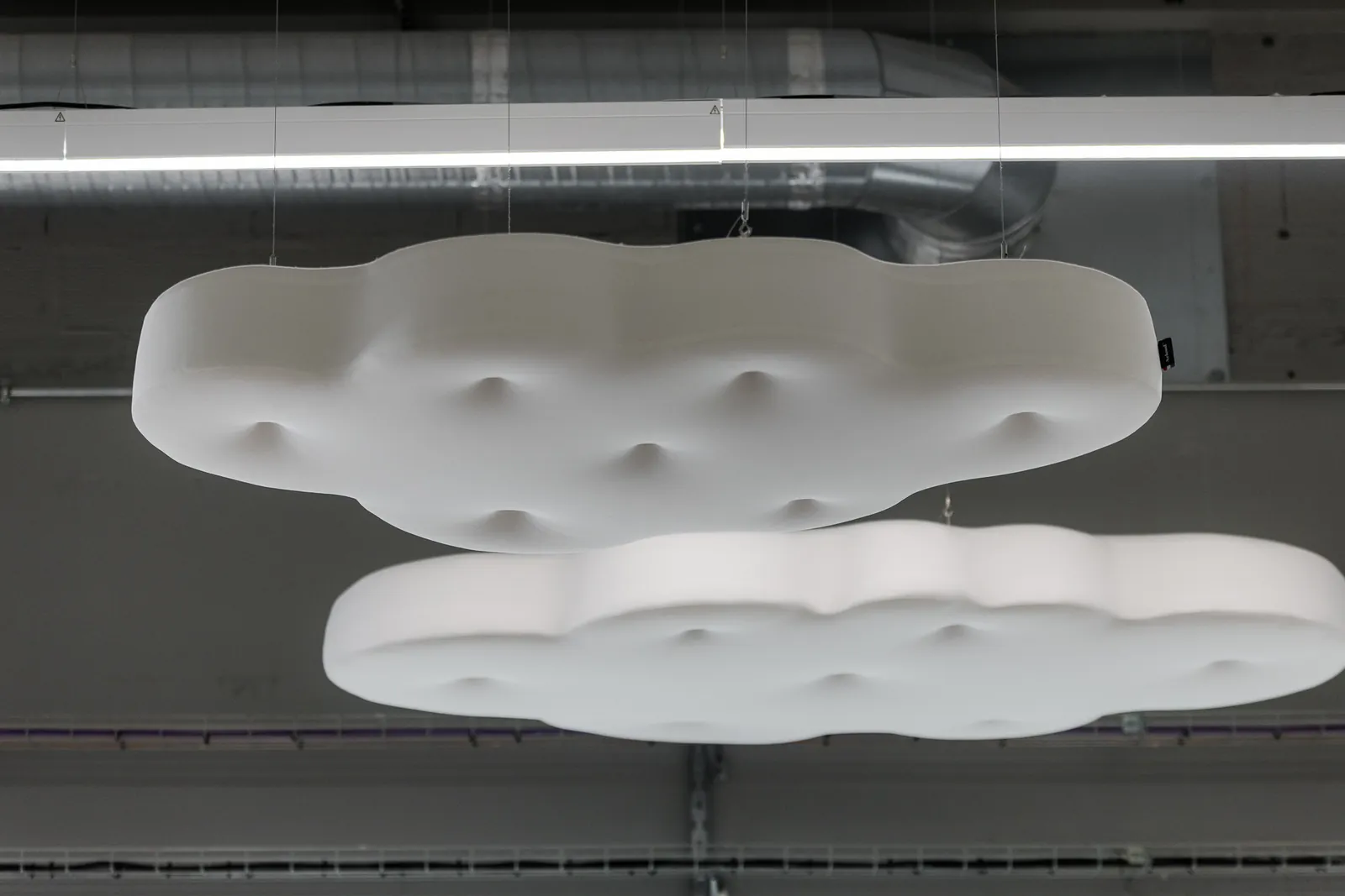 Dos nubes Acloud suspendidas bajo un techo industrial